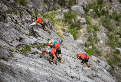 Descripción: Un grupo escalando una montaña rocosa.