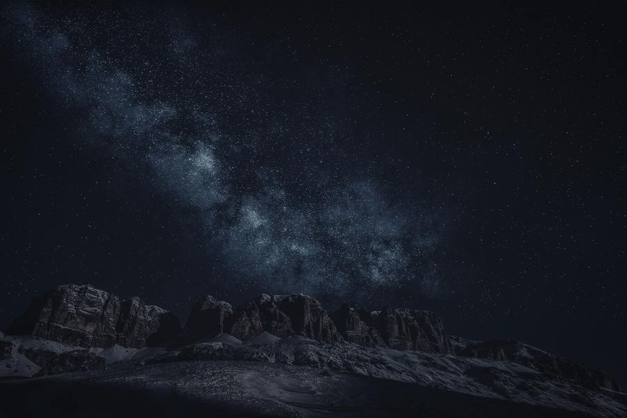 La nocturna en el cielo nocturno sobre una montaña nevada.