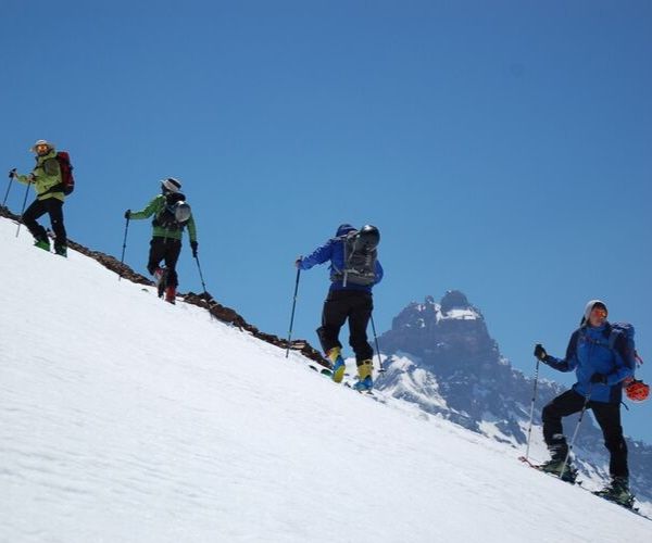 Un grupo de esquiadores subiendo una montaña nevada en el Paso Pehuenche.