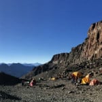 Un grupo de tiendas de campaña en la ladera de una montaña, donde los escaladores se aclimatan.