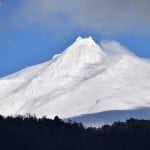 Una montaña cubierta de nieve con un cielo azul rodeado de sur.