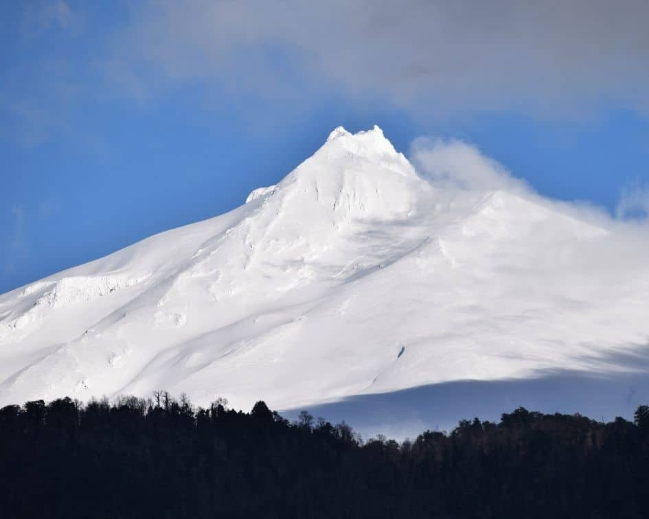 Una montaña cubierta de nieve con un cielo azul rodeado de sur.