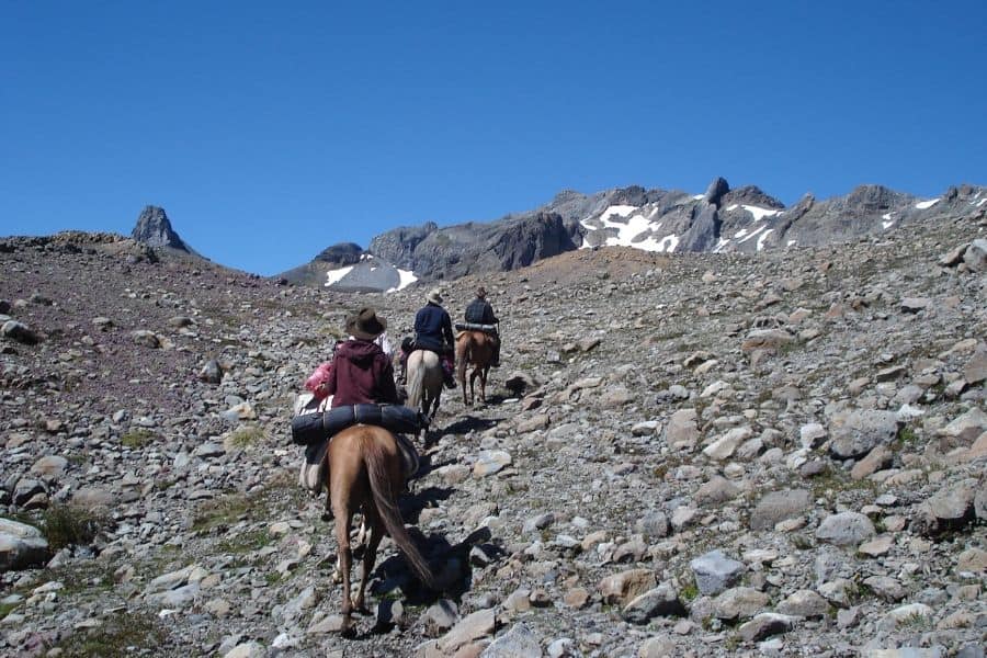 Una cabalgata cabalgando por un sendero pedregoso.