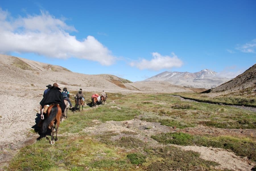 Una cabalgata de gente a caballo por una zona rocosa.