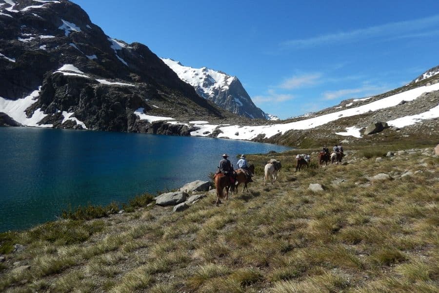 Una cabalgata cerca de un lago de montaña.