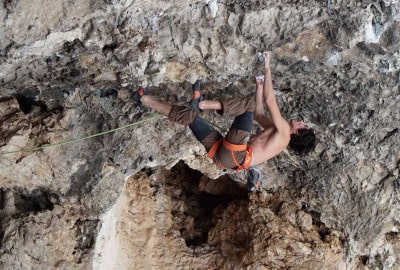 Benja Ayala está trepando a una roca en una cueva.