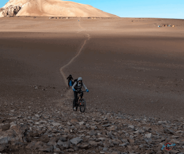 Una persona montando una gran bicicleta de montaña en el desierto.