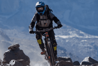 Una persona que anda en una gran bicicleta de montaña por un sendero rocoso.