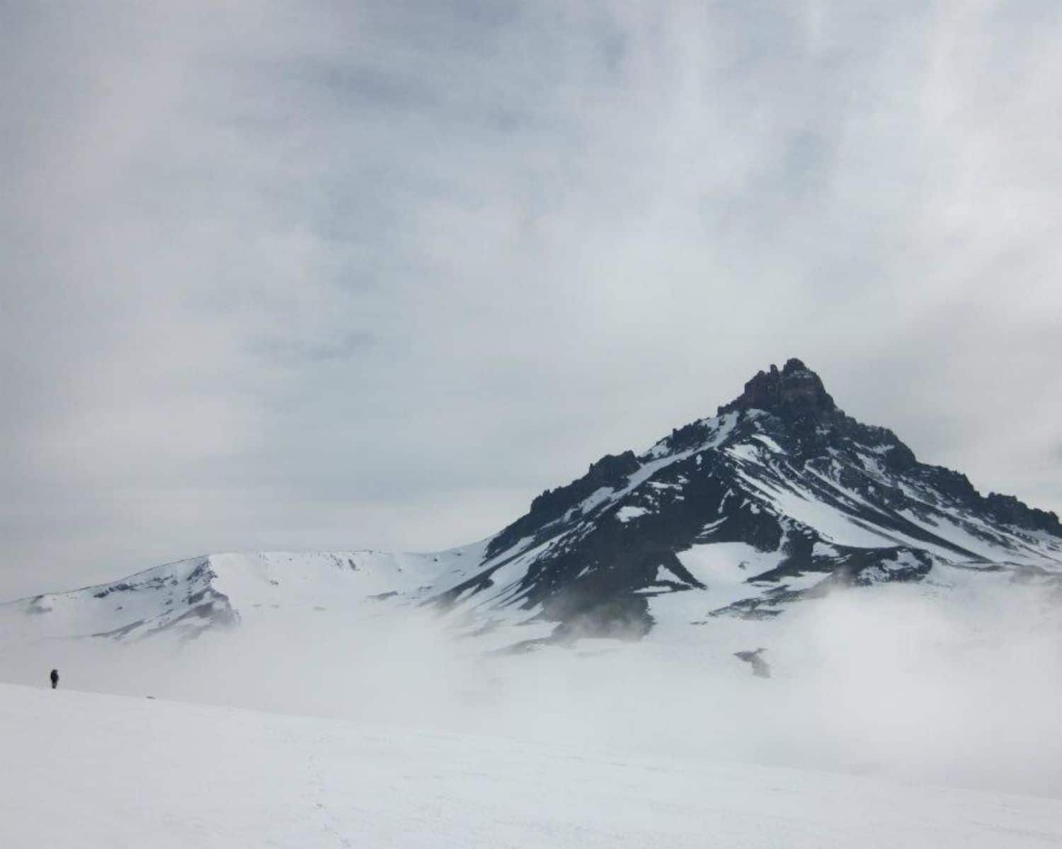 Una persona camina por la montaña nevada del Cerro Campanario.