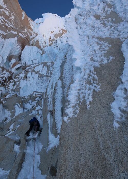 Un escalador está escalando una torre en la nieve.