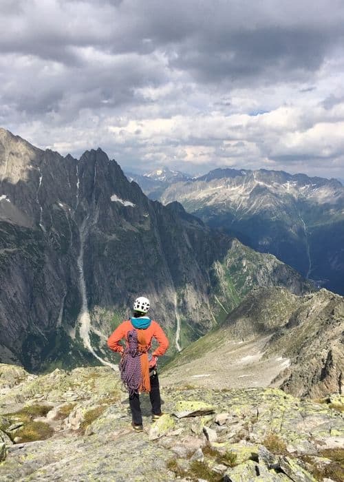 Una mujer está emprendiendo una desafiante escalada multilargo, escalando la cima de una montaña rocosa.