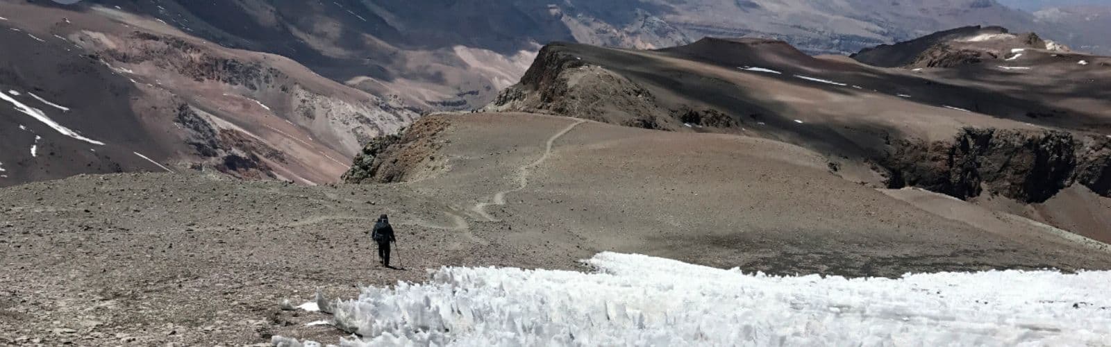 Un hombre está subiendo la altura de una montaña.