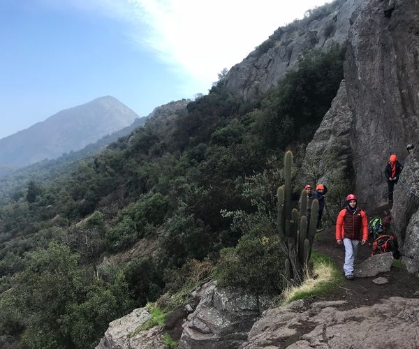 Santiago y un grupo de personas escalando una montaña rocosa.
