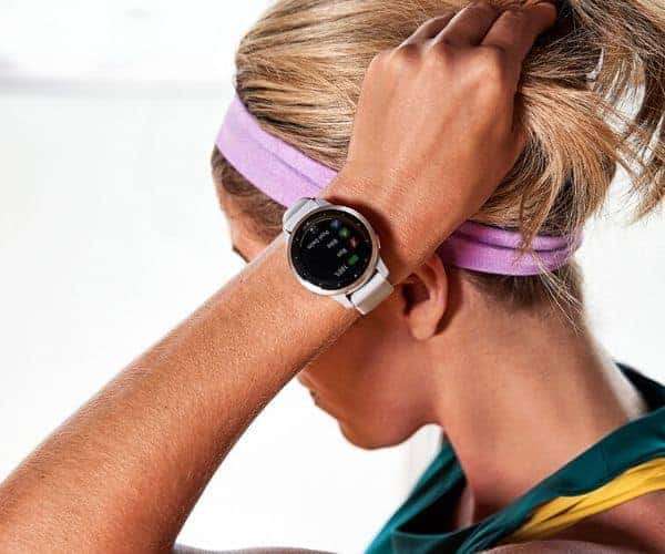 Una mujer que lleva un reloj inteligente con función GPS y una diadema en la cabeza.
