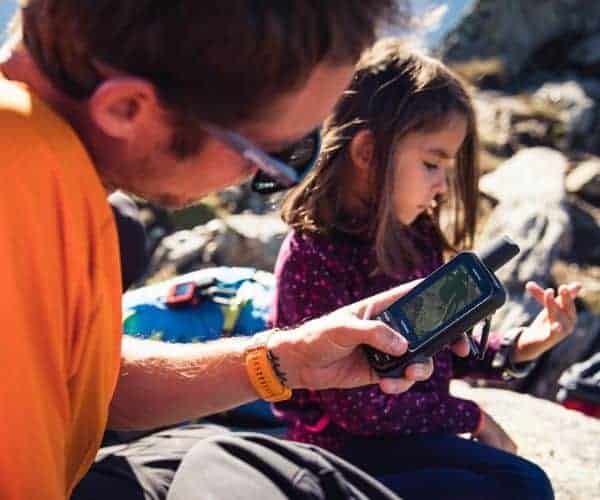 Un hombre y una niña usando un dispositivo GPS.