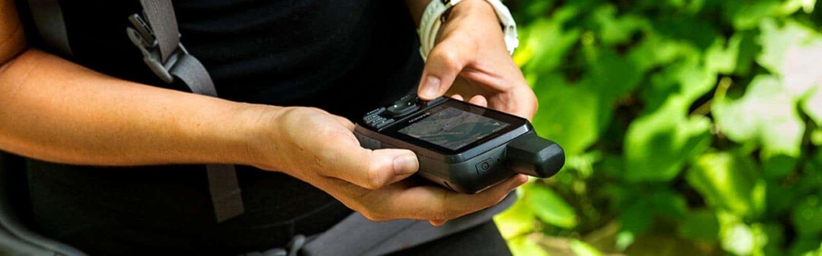 Una persona que sostiene una pequeña cámara equipada con un GPS en la mano.