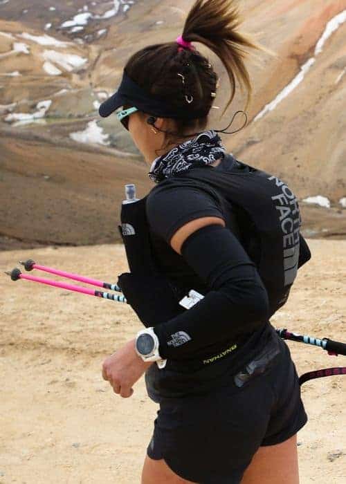 Un atleta de resistencia con una chaqueta negra y bastones de esquí.