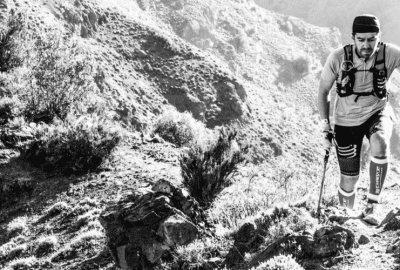 Una fotografía en blanco y negro de una persona en un sendero de montaña.