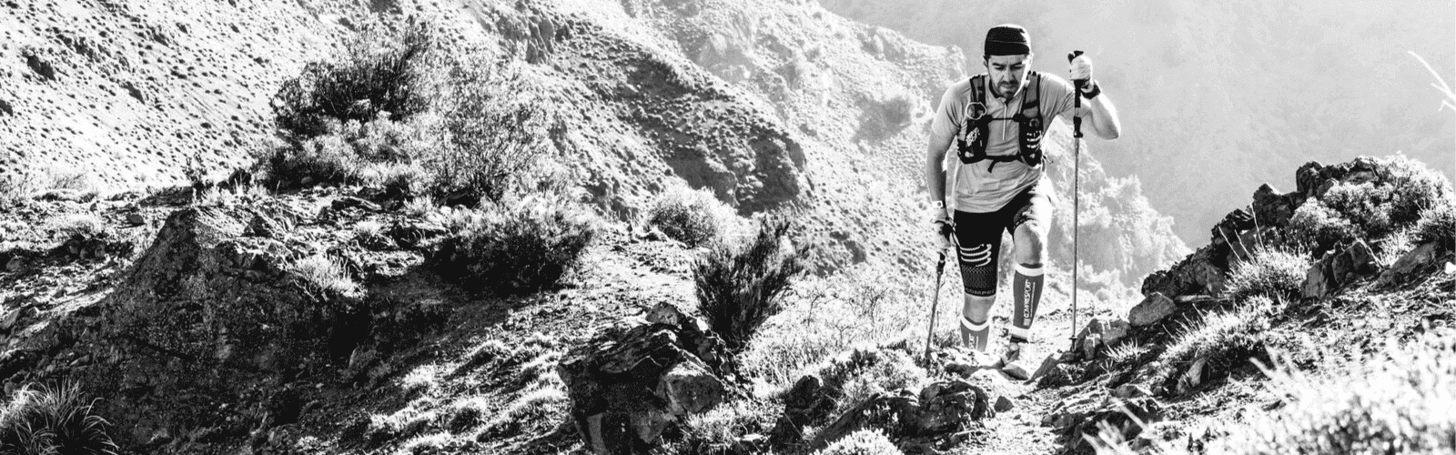 Una fotografía en blanco y negro de una persona en un sendero de montaña.