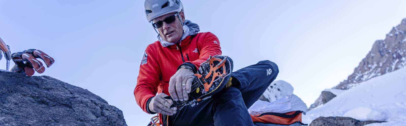 Un hombre con una chaqueta roja sentado encima de una roca anker.