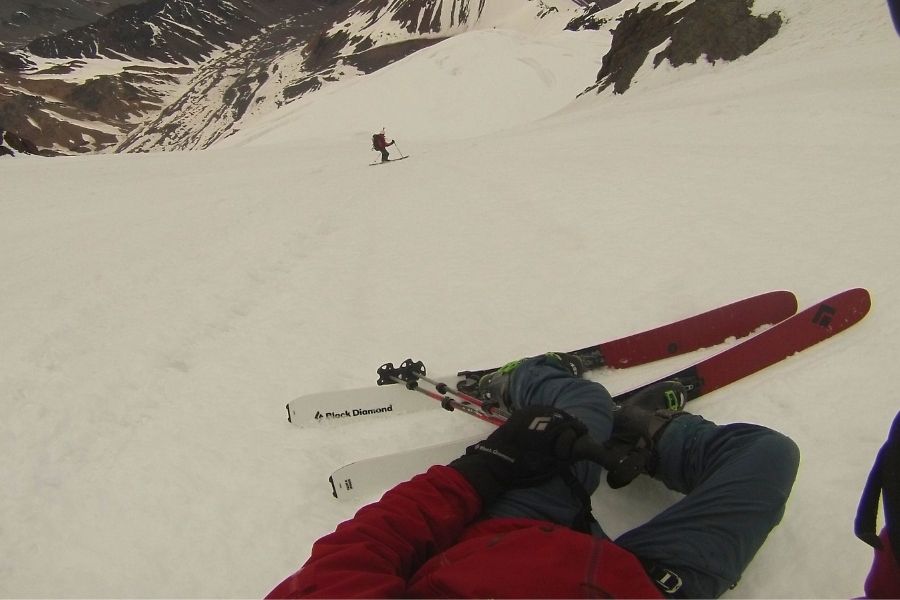 Una persona tumbada sobre una ladera nevada con esquís en El Morado.