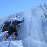 Descripción: Un escalador de hielo subiendo por una gran pared de hielo.