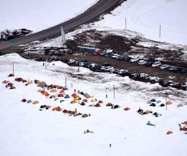 Descripción: Un grupo de tiendas de campaña montadas en una ladera nevada.