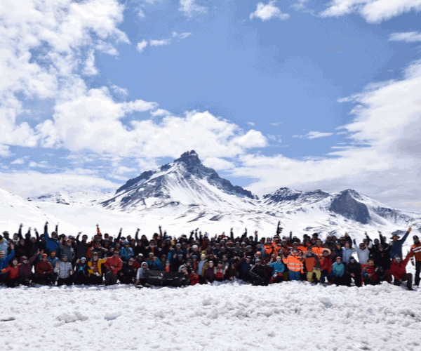 Un grupo de personas posando para una foto en la montaña cubierta de nieve.