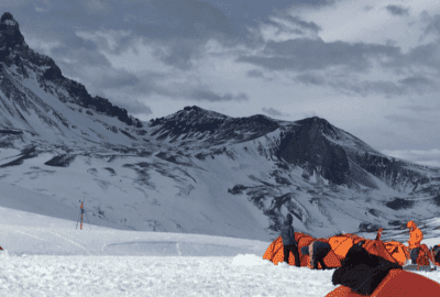 Varias tiendas de campaña de montaña instaladas en una montaña nevada.