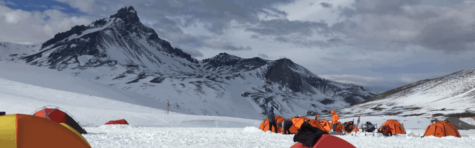 Varias tiendas de campaña de montaña instaladas en una montaña nevada.