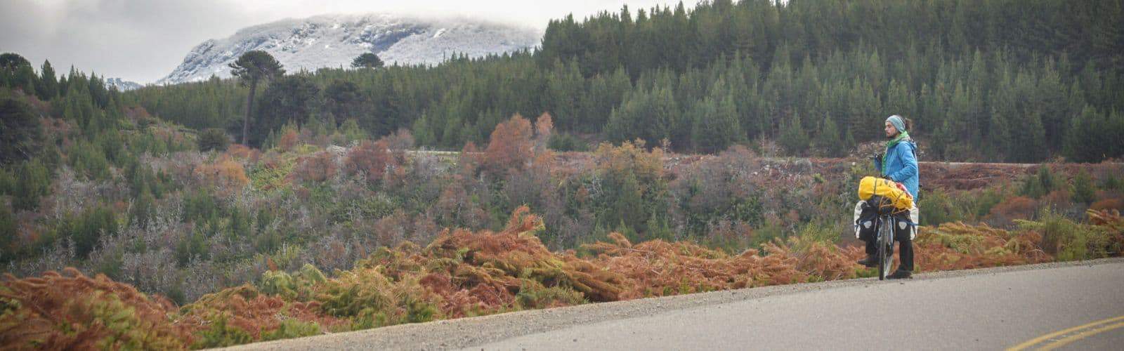 Una persona en bicicleta disfrutando de una emocionante aventura de cicloturismo por una impresionante carretera de montaña.
