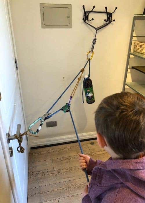 Un niño disfruta de un juguete de cuerda en una habitación, rodeado por su familia.