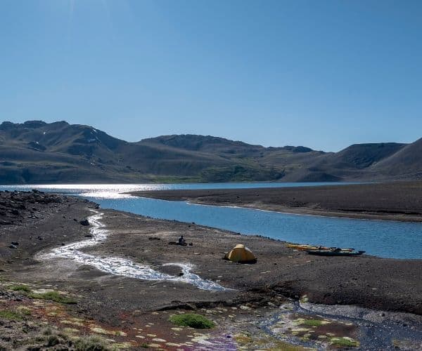 Un lago en medio de un desierto con montañas al fondo es un destino ideal para acampar. Las aguas serenas también ofrecen oportunidades para practicar kayak, lo que agrega un toque aventurero a la experiencia.