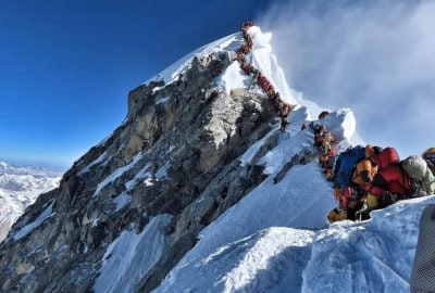 Un grupo de escaladores ochomil escalando la ladera de una montaña.
