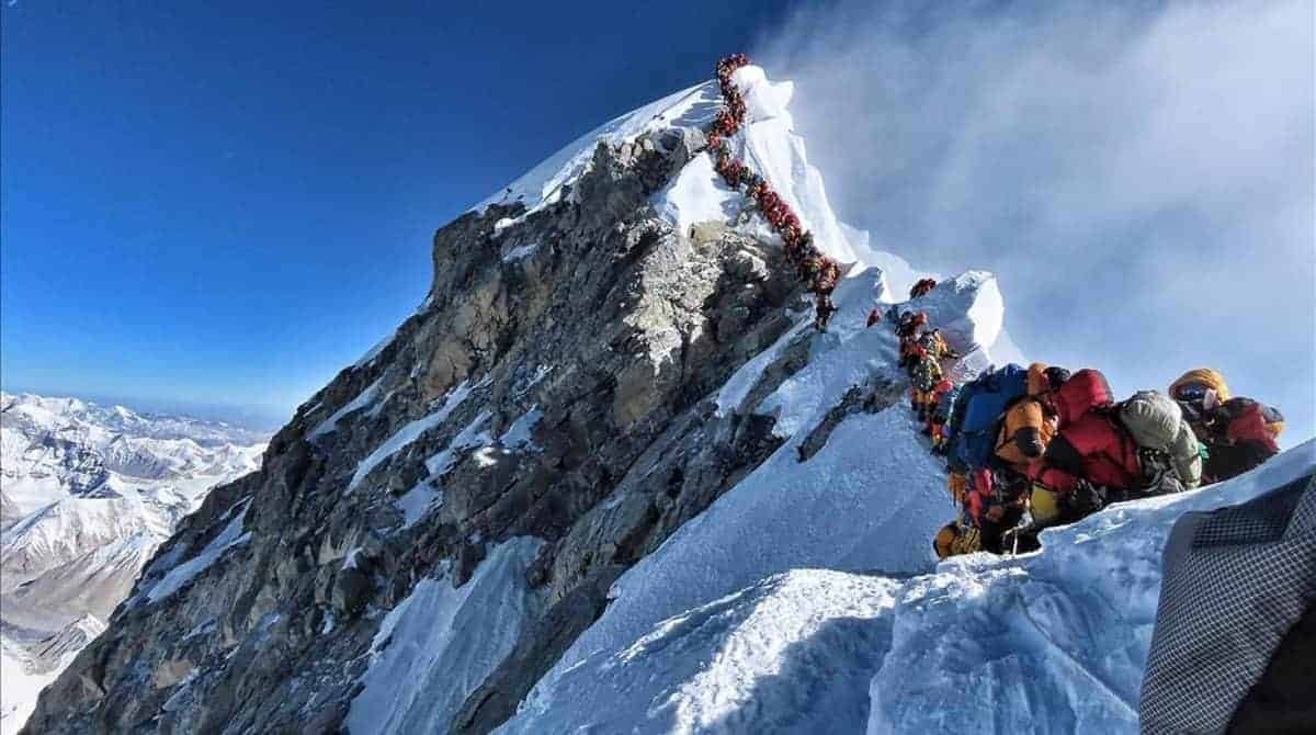 Un grupo de escaladores ochomil escalando la ladera de una montaña.