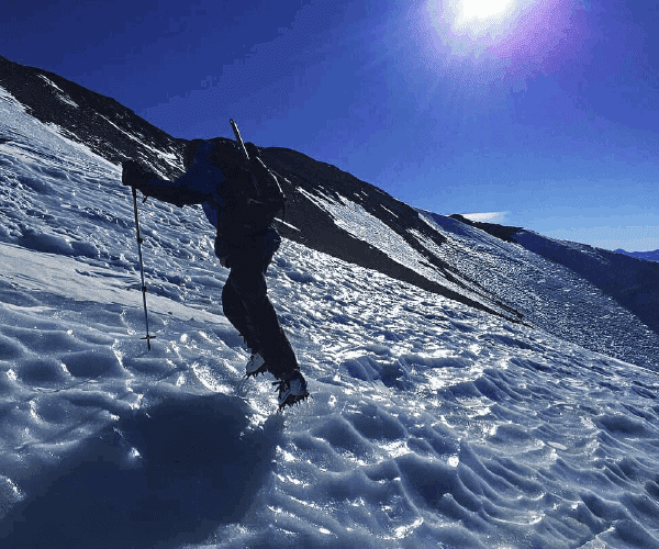 Una persona subiendo una montaña nevada de plomo.