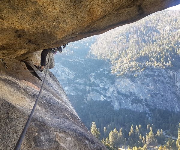 Un escalador de cuerdas cuelga de una roca en Yosemite.