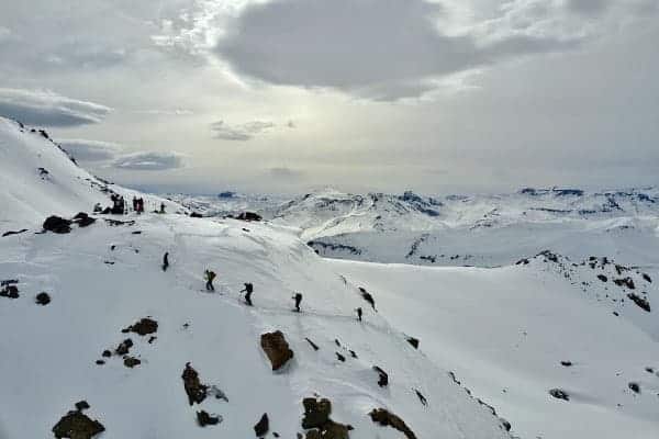 Un grupo de randos subiendo una montaña cubierta de nieve.