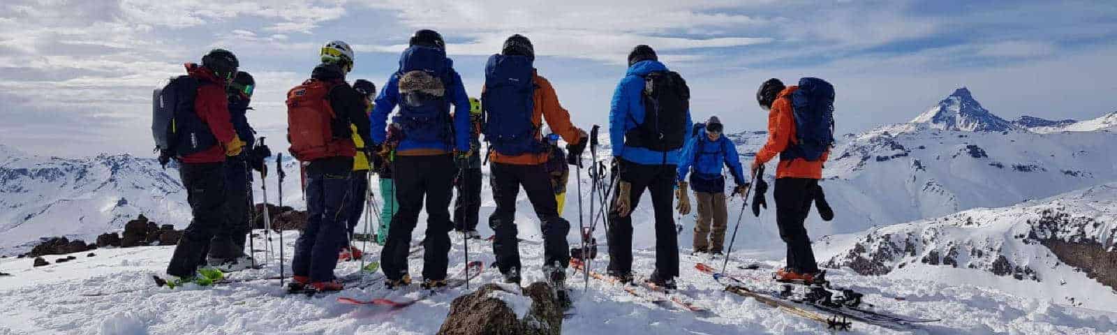 Un grupo de randos parados en la cima de una montaña.