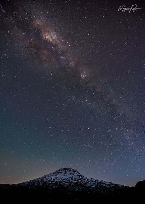 La vía láctea sobre una montaña cubierta de nieve.