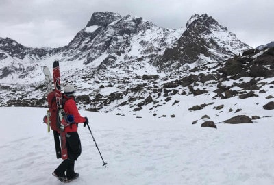 Una persona caminando con esquís sobre una montaña nevada, disfrutando de la vista panorámica.