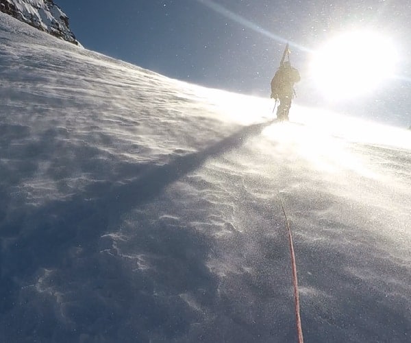 Una persona está esquiando por una pendiente cubierta de nieve a gran altitud.