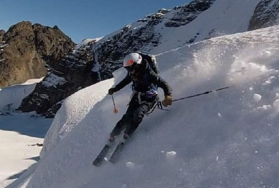 Un esquiador desciende una montaña nevada a gran altura.