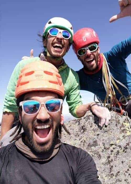 Un grupo de escaladores posando para una selfie en la cima de una montaña.