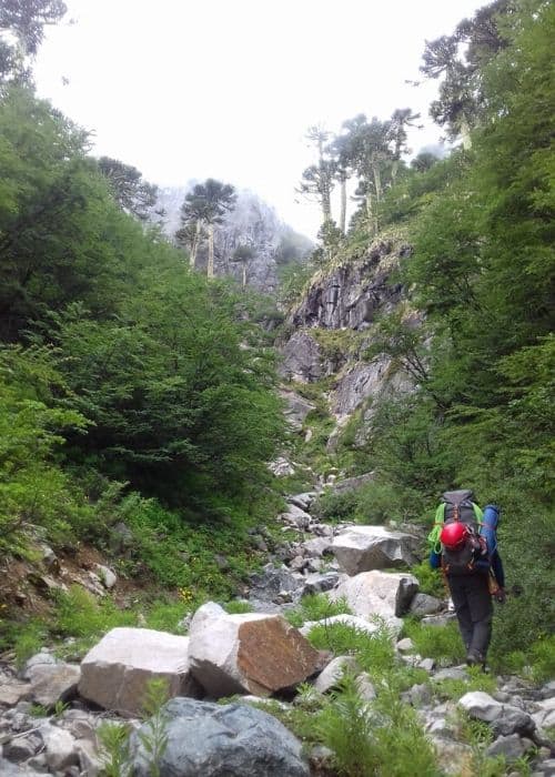 Un excursionista peinetas por un sendero rocoso en las montañas.