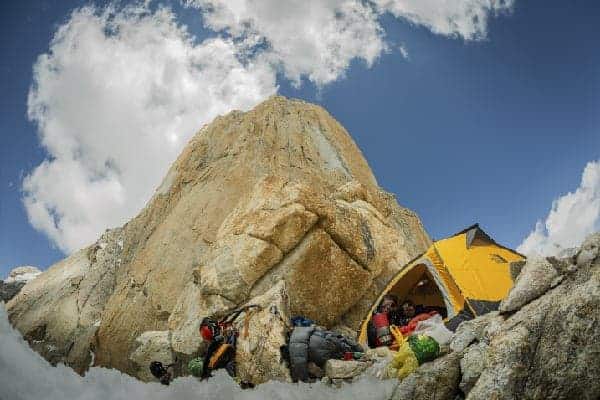 Un grupo de personas montando su tienda de campaña en la majestuosa montaña del Trango.