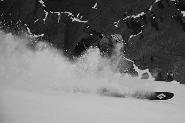 Una fotografía en blanco y negro de una persona esquiando por una montaña.