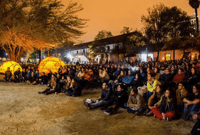 Una gran multitud de personas se reunieron en una sala de cine, absortas viendo una película en una pantalla.