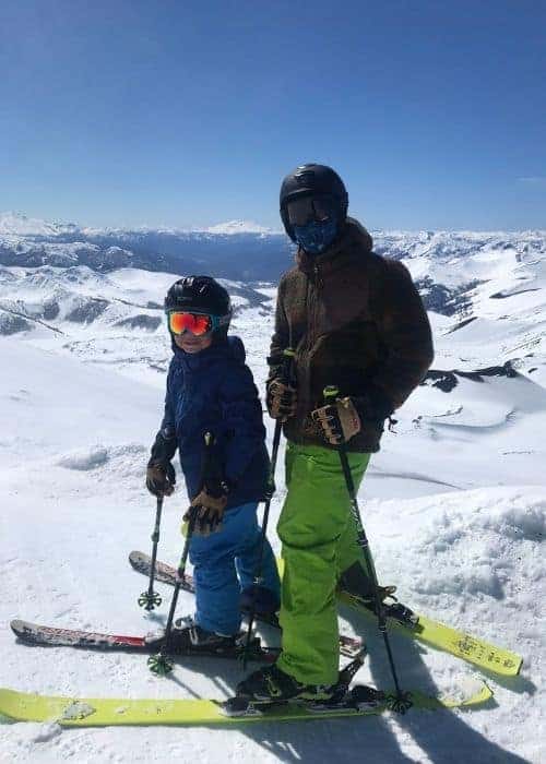 Un hombre amante de las aventuras y su familia disfrutan de una escapada al aire libre, deslizándose con esquís por una montaña cubierta de nieve.
