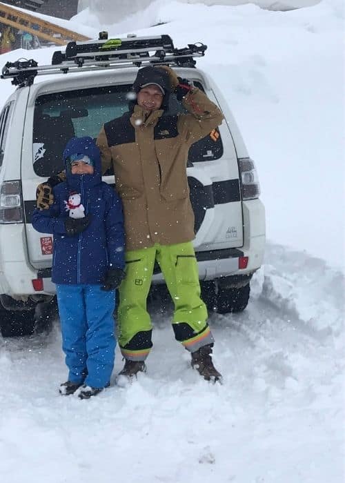 Un hombre y un niño teniendo una aventura al aire libre en la nieve.